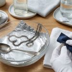 Порівняння чищення срібла фольгою та полірування серветкою в білих рукавичках.